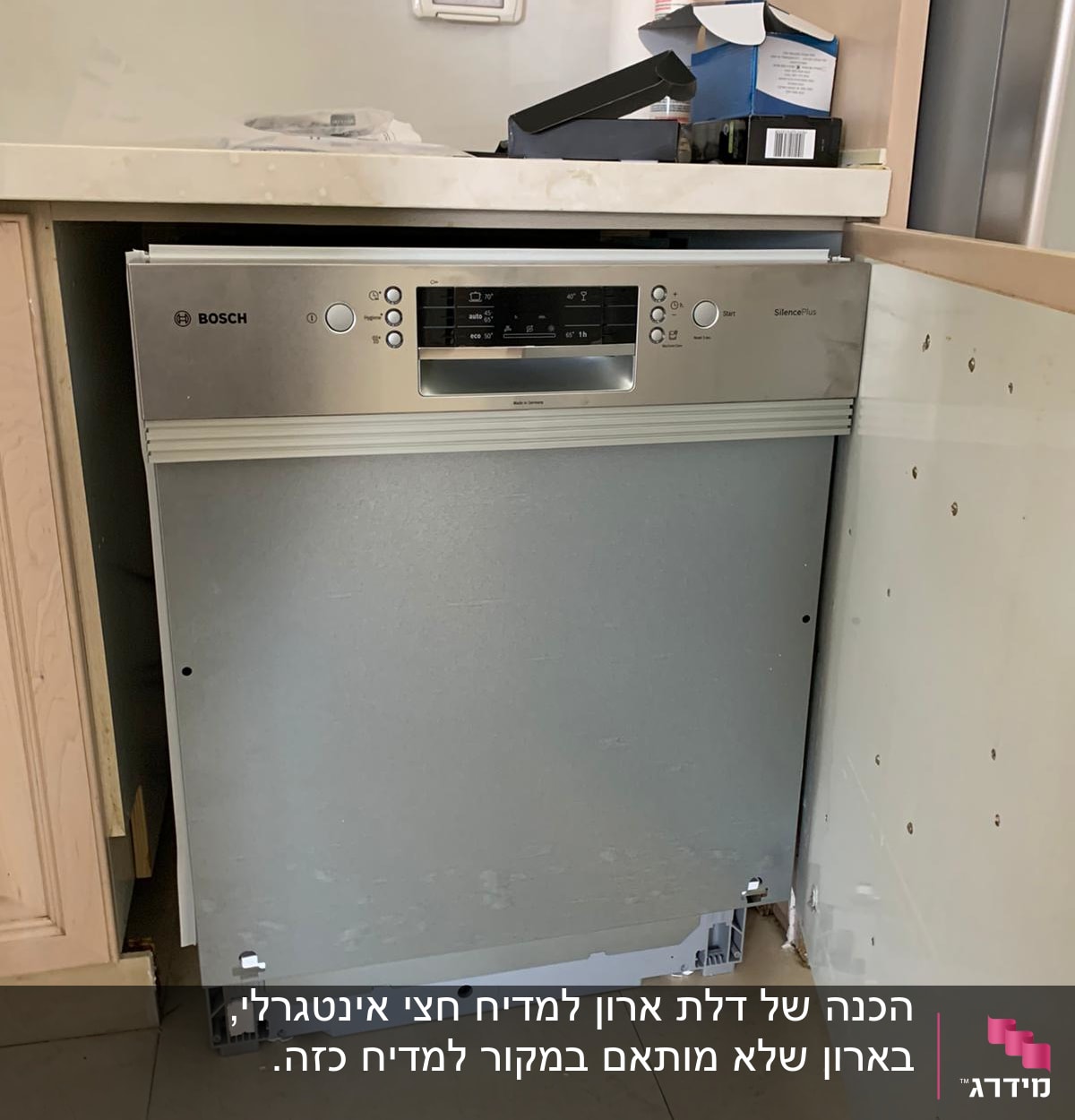 מדיח כלים מותקן חלקית במטבח עם כלים על השיש